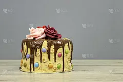 生日层蛋糕装饰巧克力块和生日快乐的文字，榛子和玫瑰花在木桌子上