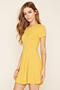 A ribbed knit skater dress featuring a cutout back and short sleeves.