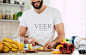 英俊的年轻运动微笑的男人在厨房准备素食健康的水果沙拉和冰沙在一个好心情图片-商业图片-正版原创图片下载购买-VEER图片库