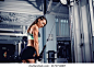 Fit well-trained woman workout triceps lifting weights in gym. Athletic sexy woman doing exercise using machine in gym - side view. High quality photo