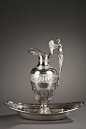 A silver ewer provided with a winged putto-shaped high handle resting on an angel head. A wide frieze with an alternation of Cupids and flowery foliages on matting background...@北坤人素材