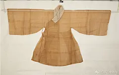 本色葛布道袍，明中后期男子夏季便服。交领、右衽、长阔袖、左右开裾式袍。镶白色暗花纱护领。右侧腋下钉系带，腰左右打暗折。衣坚韧透气，宽松肥大，织造精良。
葛布，俗称复布。用葛的茎纤纬制成的织物。多用来作夏服，质地细薄，透气性好，以浙江慈溪和广东雷州生产葛布最为著名。关于葛布最早的记载出自《诗经•葛覃》：“葛之覃兮，施于中谷。维叶莫莫，是刈是濩。为絺为綌，服之无斁。” 