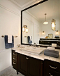 This (HIS) master bath has a traditional aesthetic. Rich, dark wood in the custom cabinetry provides a pleasant contrast with the Calcutta marble countertop, shower and floor by Ann Sacks. Photo by Jeff Garland.