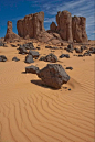 rocks and sand in the desert under a blue sky