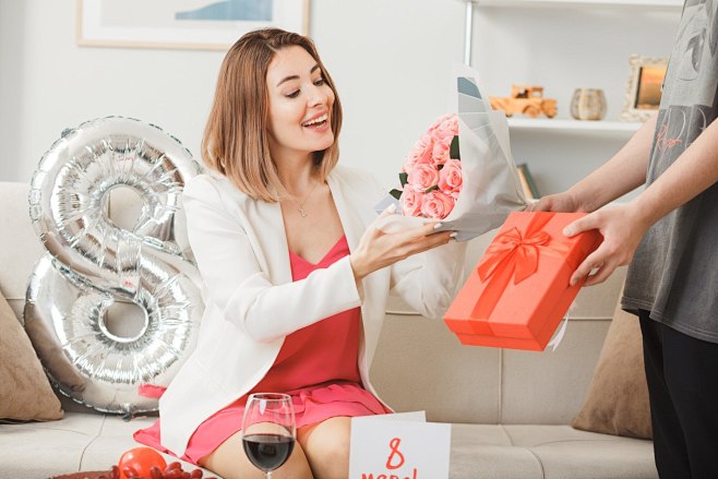 在妇女节快乐节，微笑的妇女们坐在沙发上，...