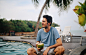 在泰国兰塔岛的海边，一个年轻人正在喝新鲜的椰汁图片素材
