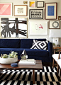 gallery wall above navy sofa: 