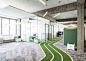 Onefootball HQ by TKEZ features turfed meeting rooms and running track : A three-lane running track weaves around this office for a football app company, by TKEZ, leading to goals for penalty shootouts during work breaks