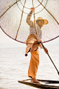 Foot fishing - 2014, Myanmar, Inle Lake. Skilled fisherman balancing his bamboo fishing net.