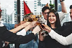 一群商务人士享受聚会，并一起碰杯香槟和葡萄酒庆祝公司的成功和新年活动