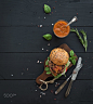 Fresh homemade burger on dark serving board with spicy tomato sauce, sea salt and herbs over black w by Anna Ivanova on 500px