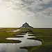 photo of grass field and spiral lake and gray castle scenery