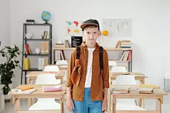 免费 站在白表附近的棕色夹克和蓝色牛仔牛仔裤的女人 素材图片