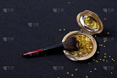 粉底和化妆刷黑色背景上的金色星星。新年快乐创意
