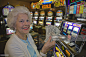 Senior woman showing winnings in casino, smiling : Stock Photo