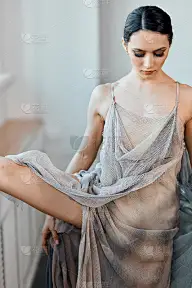 拥有完美身材和浪漫渔网裙的芭蕾舞女演员正在工作室跳舞。