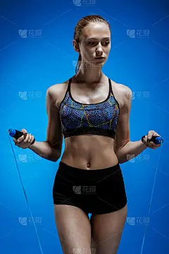 肌肉发达的年轻女子运动员用蓝色的跳绳