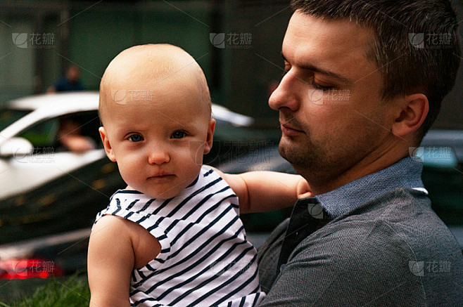 父亲怀里抱着一岁的婴儿。在城市环境中行走。城市化和城市生活的概念。情商的发展。早期的发展。