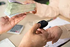 汽车经销商或保险经理将钥匙交给客户，并接受签署购买或贷款的钱