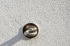 固定在建筑墙壁上的金属孔，用于悬挂和拉伸户外广告，如横幅、传单、海报，有45度角的阴影