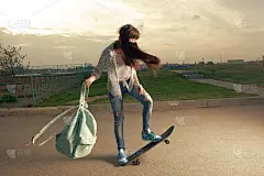 在城市里超速滑滑板的女人手里拿着背包