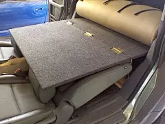 房车驾驶室活用方法，驾驶座椅靠背放倒，与后面拼成单人床。多加看一块垫子放在下面，用来放平床板。