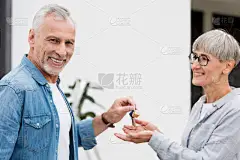 成熟的男人把新房子的钥匙送给微笑的女人 