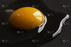 生鸡蛋放在黑色的表面上。生鸡蛋上的蛋黄和蛋白质呈黑色，侧面可见。