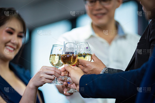为成功。一群商务人士用香槟敬酒，微笑着站在每个人旁边