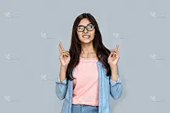 紧张的年轻印度女学生咬嘴唇交叉手指祝好运前考试概念孤立在灰色工作室背景，迷信搞笑青少年希望赢相信迷信