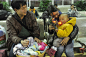 1月20日晚，在杭州火车站候车厅，来自贵州遵义的1岁半男孩何志博在母亲的怀里把玩特意带回家过年的玩具枪，他们将乘坐L199次列车返乡