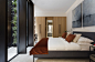 <p>The lower ground floor's flexible spaces, such as this bedroom, are well lit by a courtyard cut through the plan and reaching down below ground level</p>