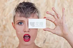 惊讶的女孩用名片靠近眼睛