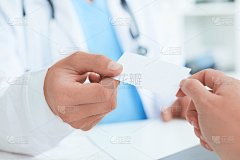 在办公室男医生手给女特写白色空白名片。身体、疾病预防、检查病人、器械店、健康生活方式、家庭医生理念
