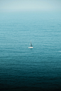 A lone sailboat in the middle of the ocean