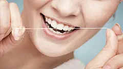 Girl cleaning teeth with dental floss. Health care
