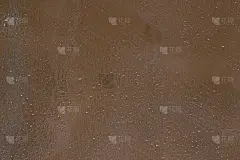 一块玻璃表面的碎片被一层融化的冰覆盖在深棕色的背景上。特写镜头。