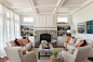 Inspiration for a mid-sized coastal medium tone wood floor living room library remodel in Providence with beige walls, a standard fireplace, a stone fireplace and a concealed tv