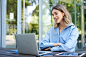 portrait-corporate-woman-working-outside-office-remote-sitting-with-laptop-wireless-earphones