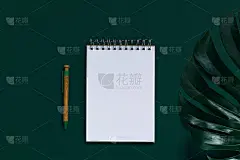 用一根钢笔在绿色背景上用怪兽树叶做的手工纸做的记事本。