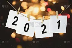 一根绳子上挂着写着“2021”的白纸，背景是彩色的散焦