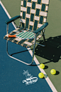 其中可能包括：a lawn chair sitting on top of a tennis court next to some balls and a racquet