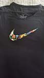 This may contain: a t - shirt with the word nike painted on it's chest and colorful flowers