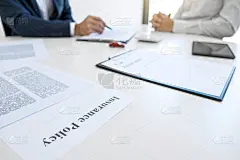 商人将会签署一份汽车保险单，而代理人则拿着并指着这份文件完成