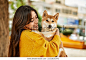 Beautiful young woman hugging happy shiba inu dog at park