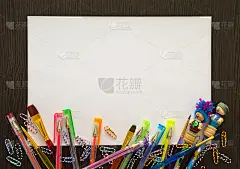 空白的白纸作为你的文本。周围有彩色铅笔，钢笔，回形针。