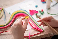 Quilling 技术。制作装饰品或贺卡。纸条, 花, 剪刀。手工工艺品在假日: 生日, 母亲或父亲