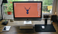 A computer workspace with an iMac, an iPad Mini and a smartphone in a dock