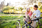 Beautiful senior couple with bicycles outside in spring nature.