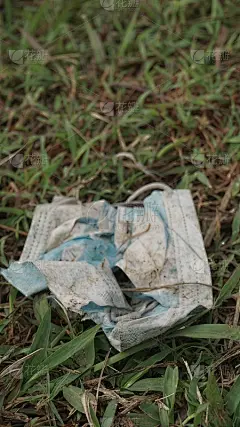 随手扔在灌木丛中的医用口罩，看起来很脏